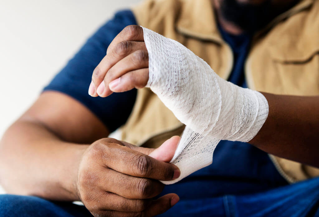 Person wraping his hand with a bandage