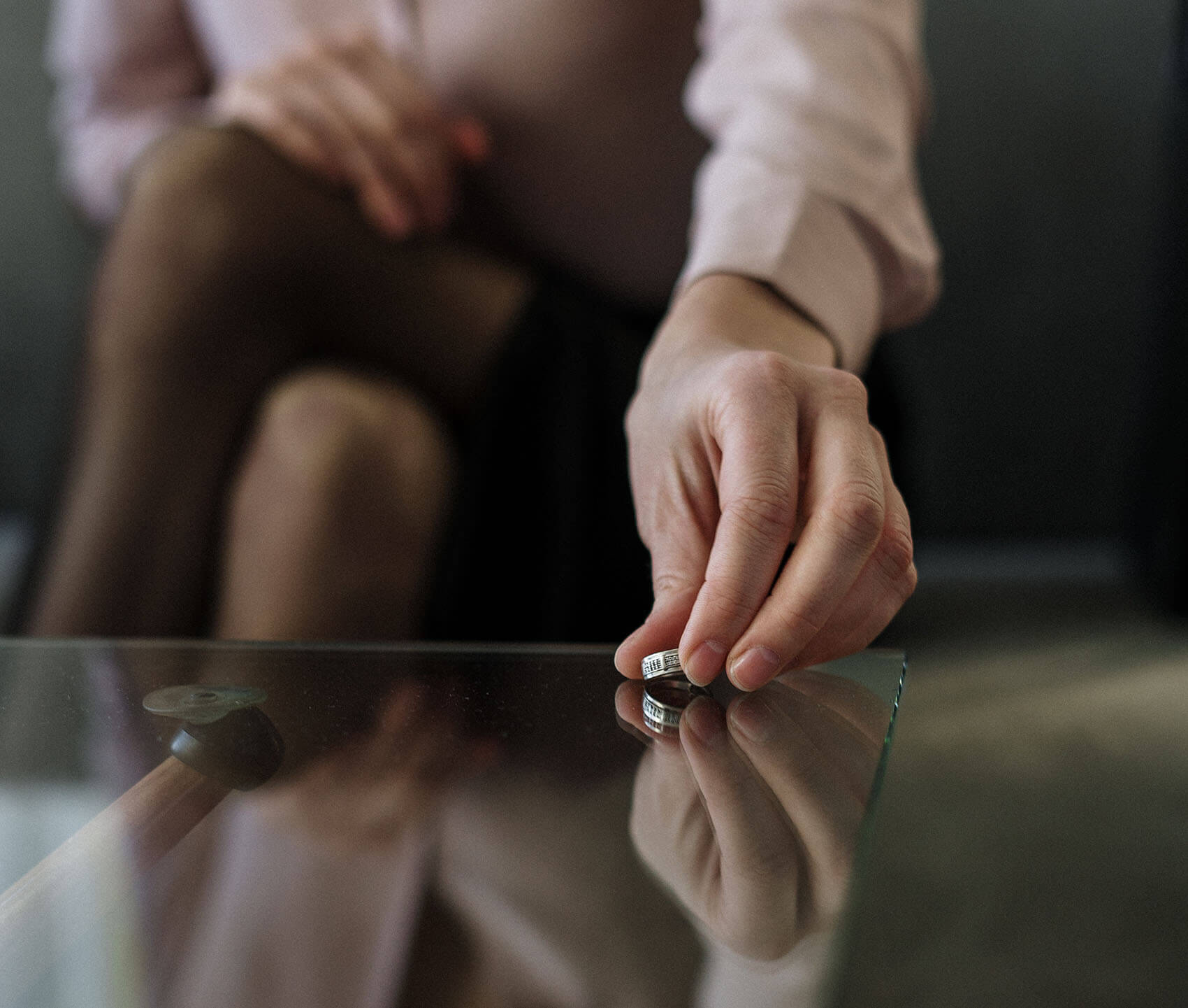 woman placing a ring on a glass table