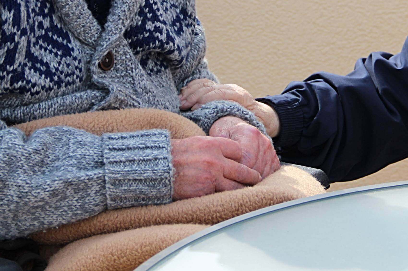 person holding an elderly person's arm